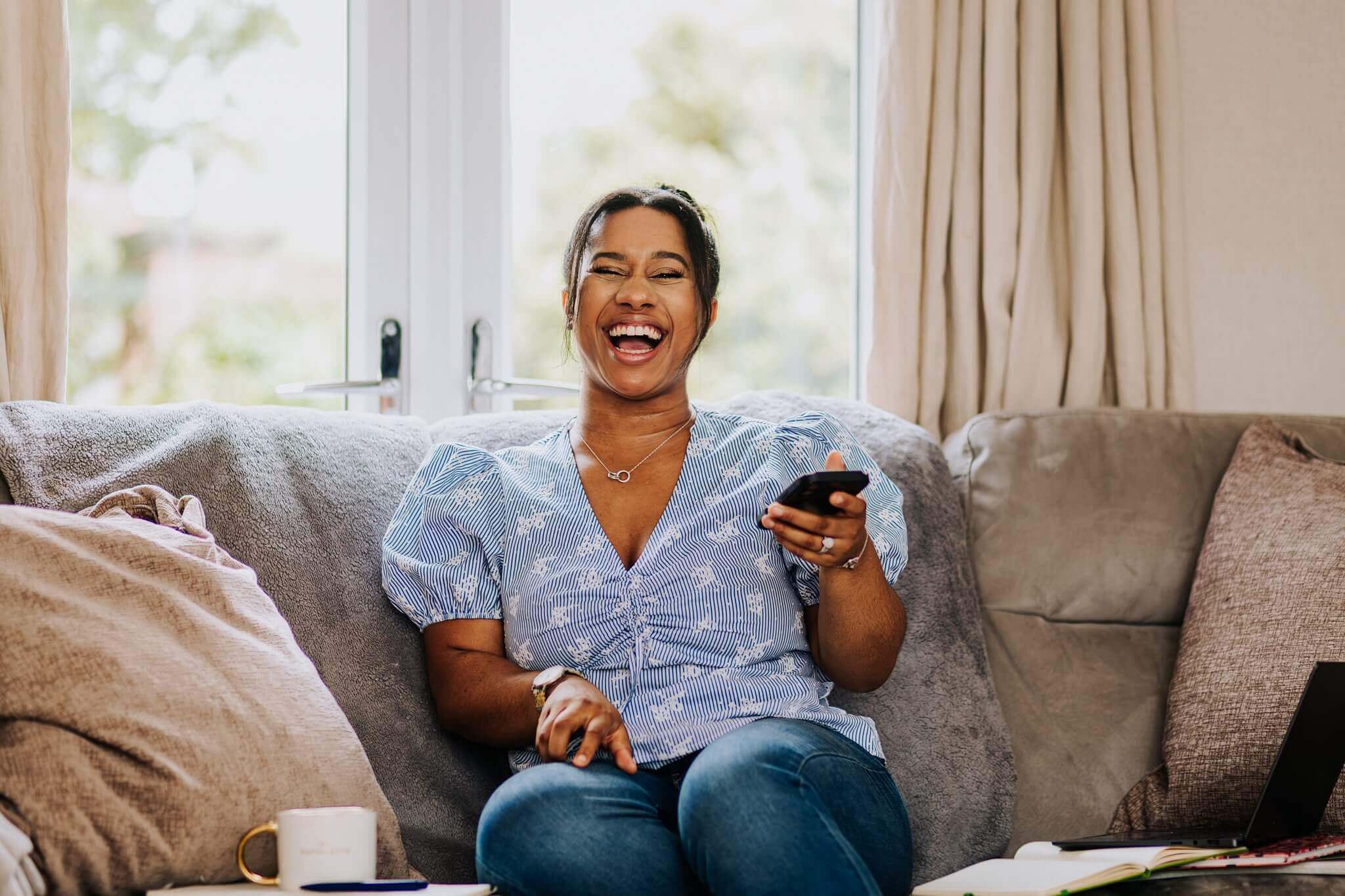 Chanelle smiling on a sofa at home