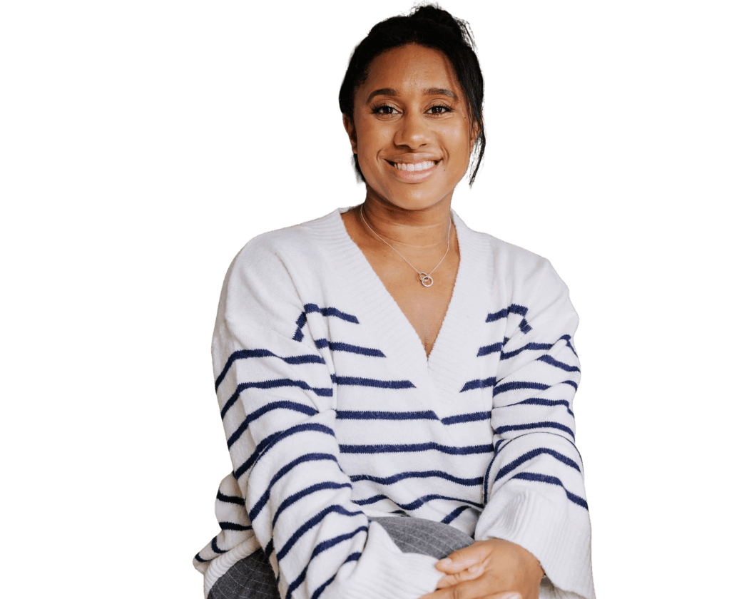 Chanelle, founder of Core People Solutions, smiling and sitting on a wooden bench